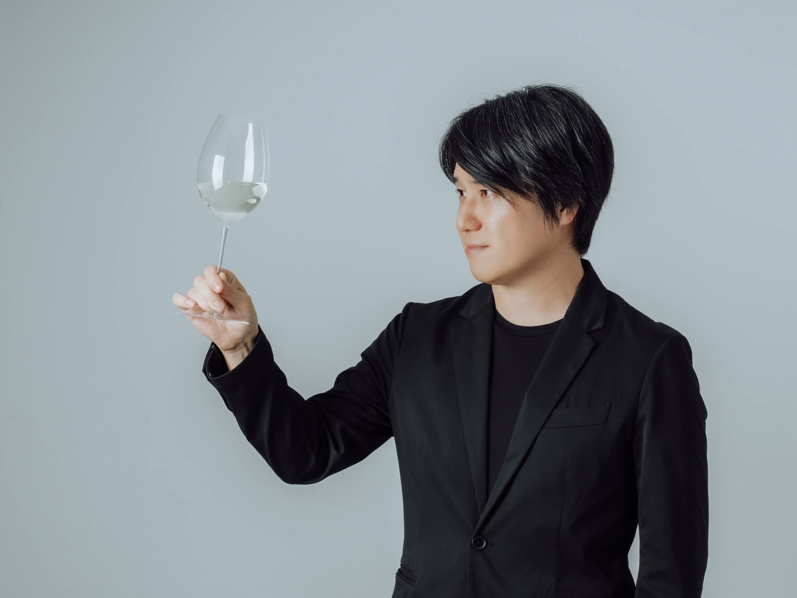 ワイングラスのステムを持つ男性のスマートな姿
